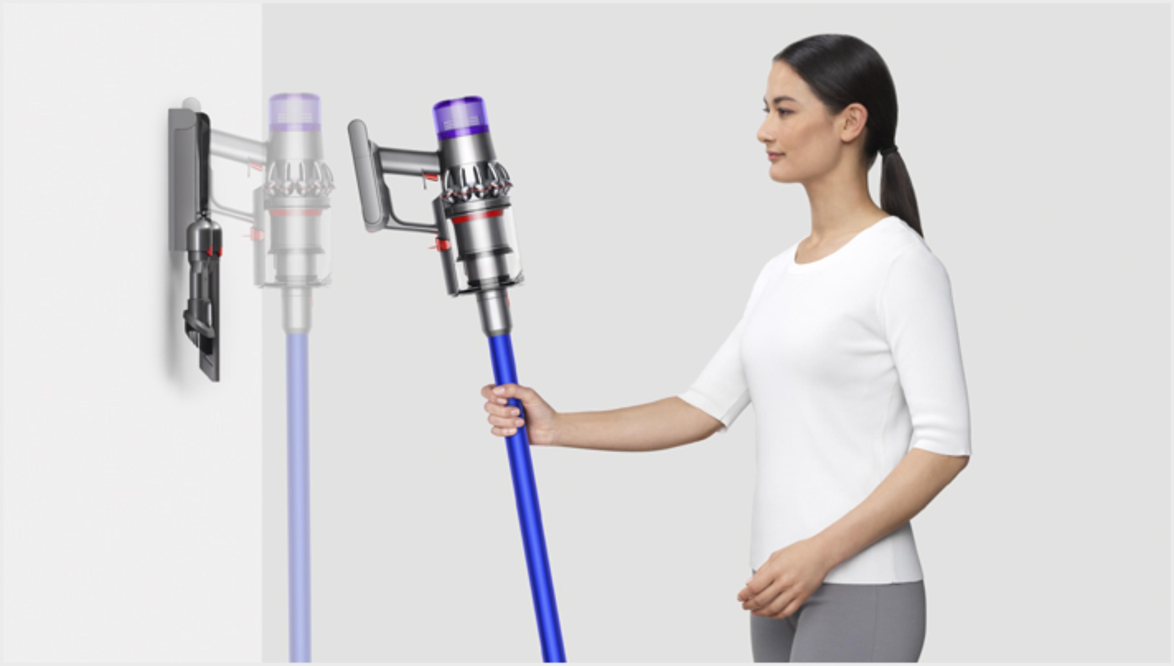 Woman placing Dyson V11™ vacuum into wall charging dock